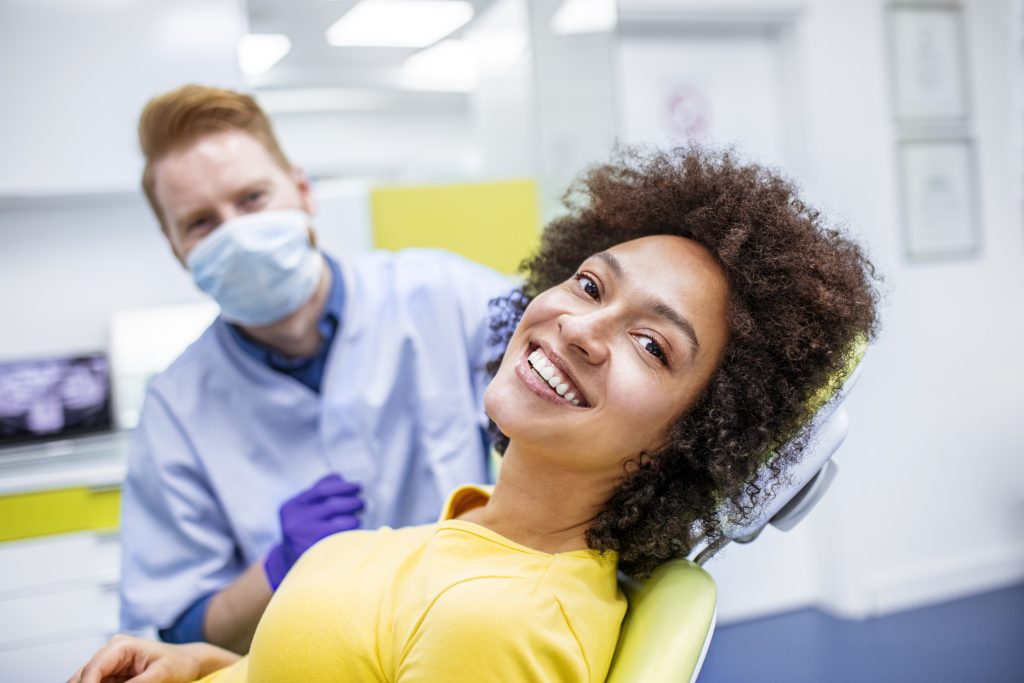 Mujer sonriente en el dentista realizando profilaxis dental