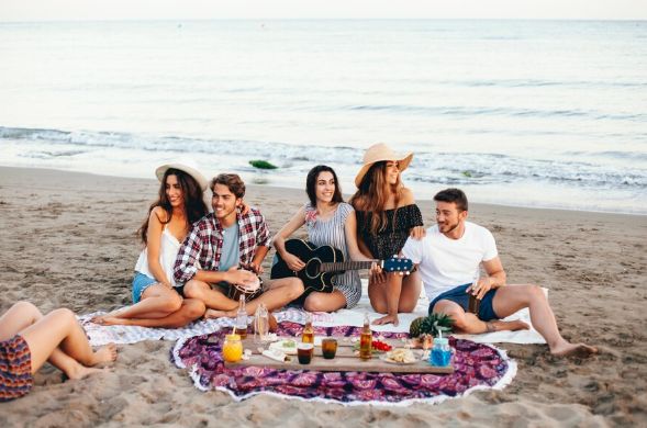 Jóvenes realizan un pícnic en una playa